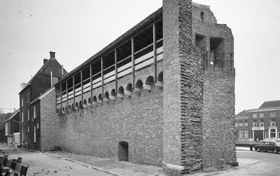 <p>Foto van de gerestaureerde stadsmuur en het gereconstrueerde deel van de Steenpoort vanuit de Waterstraat. Geheel links het onderzochte complex (beeldbank RCE). </p>

